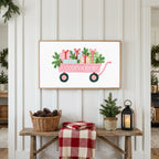 Pink wagon with gifts Frame TV art above a rustic bench with pine cones and a red check blanket on a white plank wall