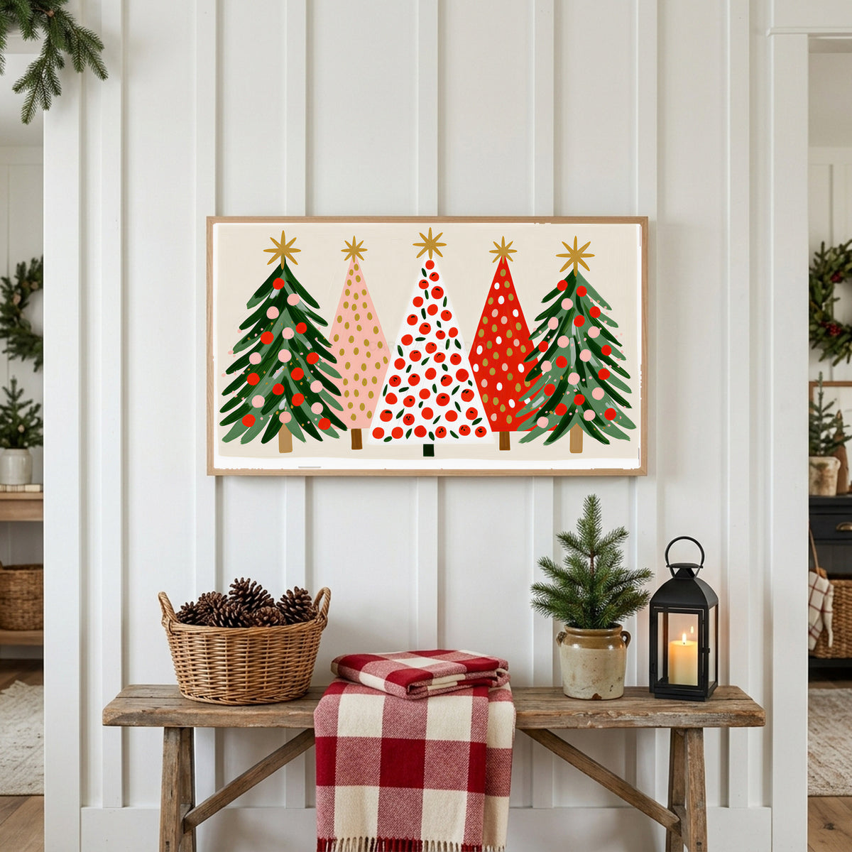 Christmas tree row Frame TV art above a rustic bench with pine cones and a red check blanket on a white plank wall