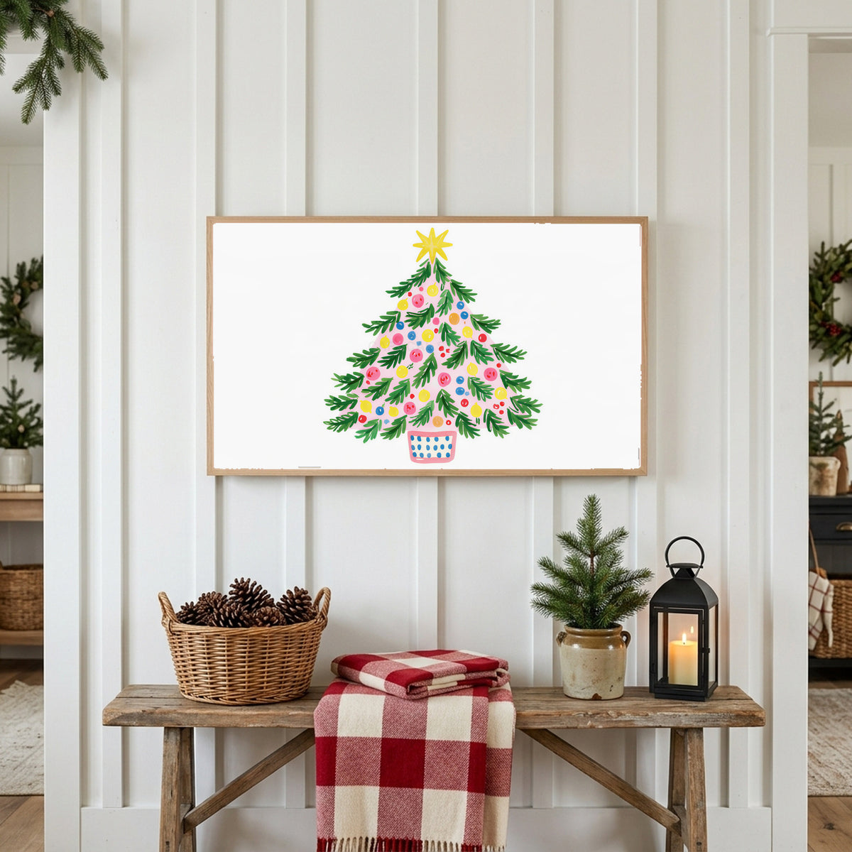 Colorful Christmas tree Frame TV art above a rustic bench with pine cones and a red check blanket on a white plank wall