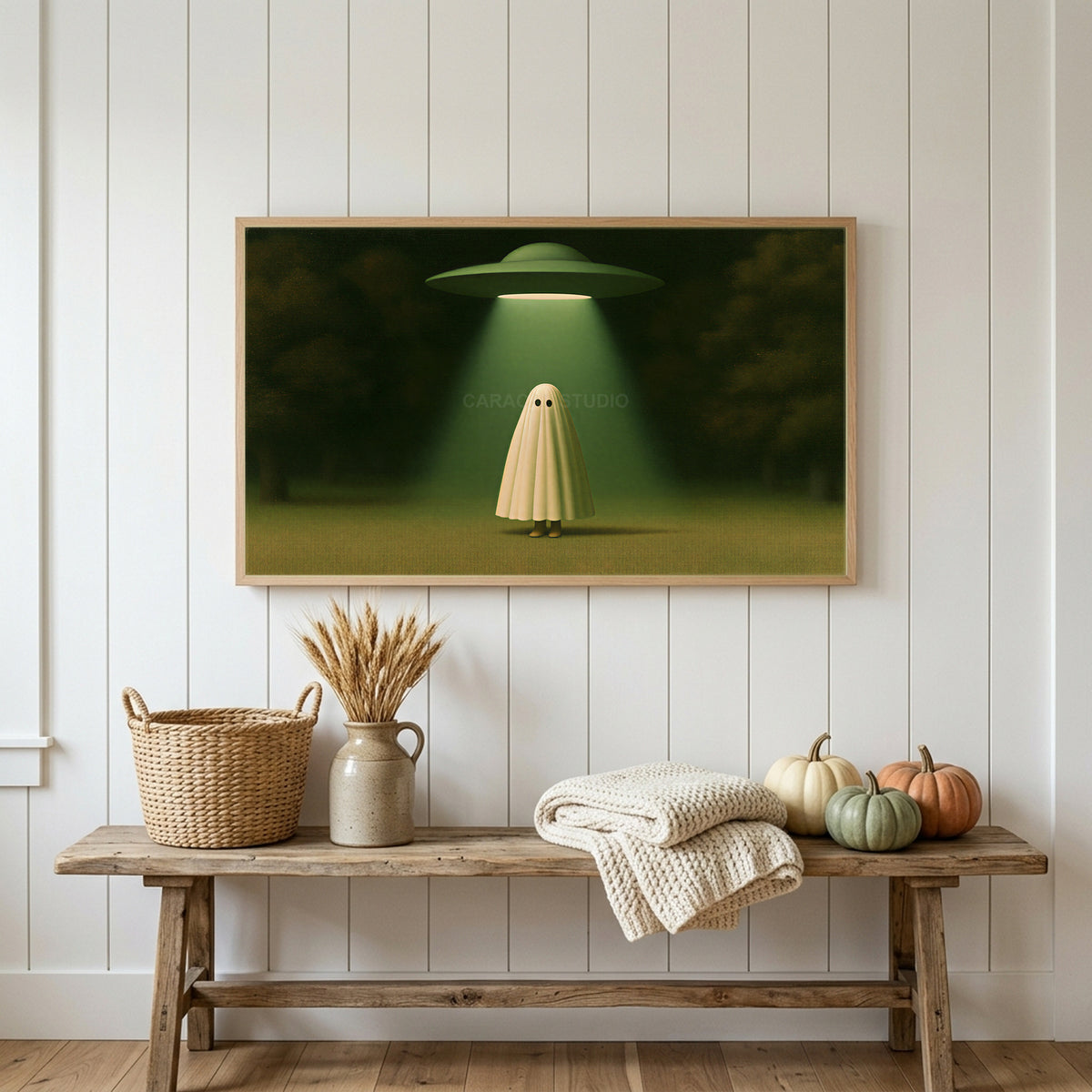 Ghost and UFO Frame TV art above a rustic bench with heirloom pumpkins on a white plank wall