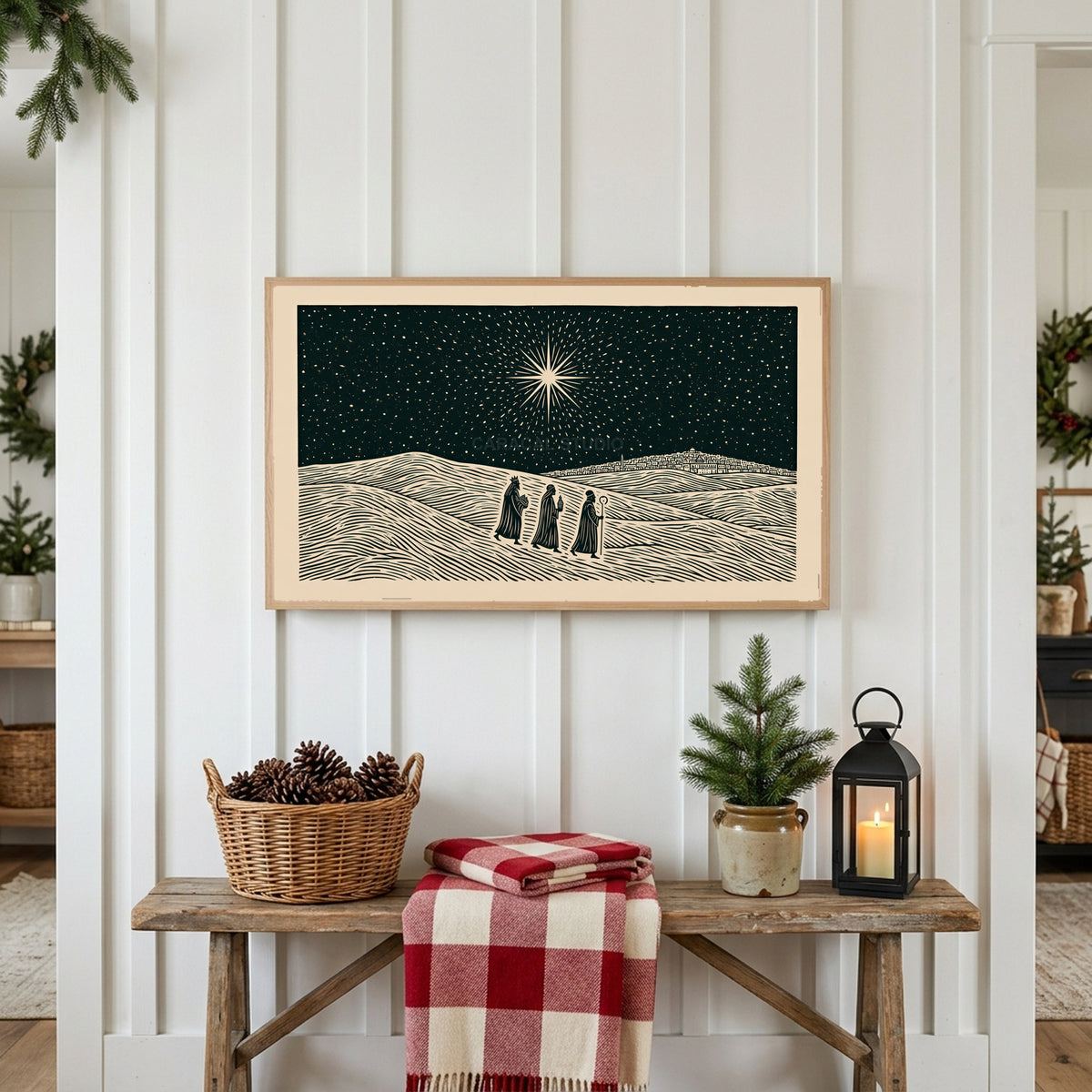 Three wise men Frame TV art above a rustic bench with pine cones and a red check blanket on a white plank wall
