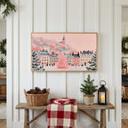 Pink Christmas village Frame TV art above a rustic bench with pine cones and a red check blanket on a white plank wall
