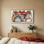 Cats under a gift box TV art above an oak dresser with small bottle-brush trees in a calm bedroom