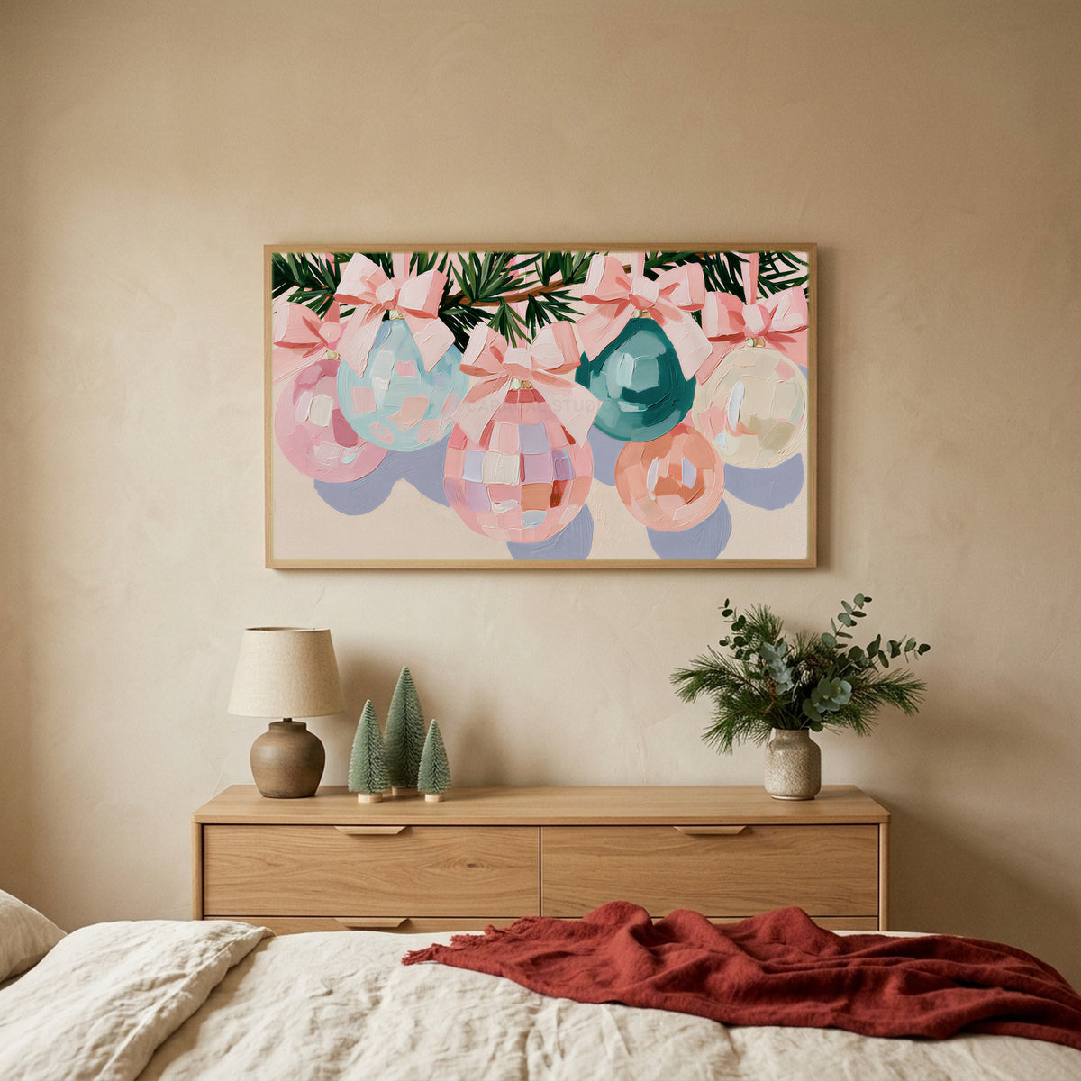 Pastel Christmas ornaments TV art above an oak dresser with small bottle-brush trees in a calm bedroom