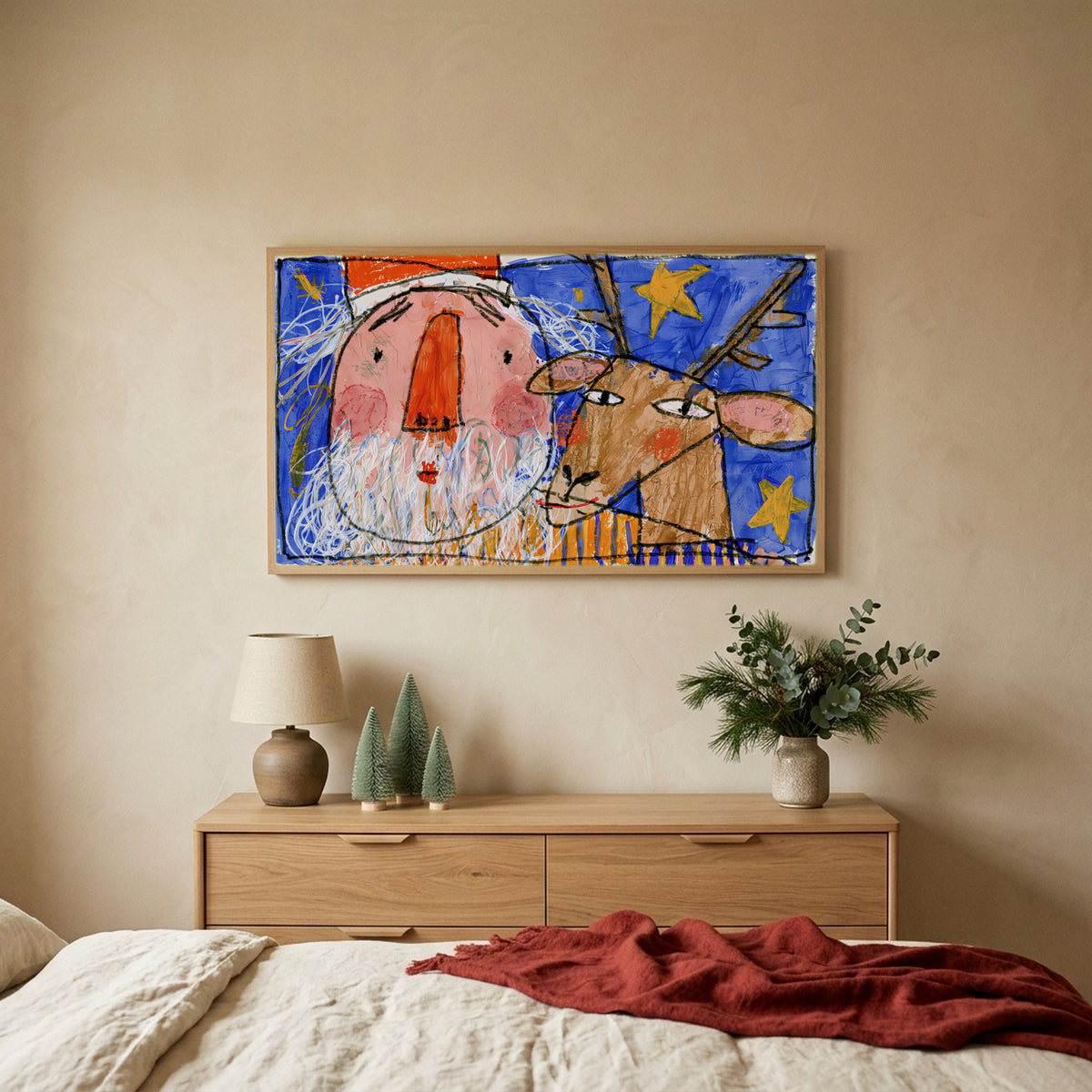 Crayon Santa and reindeer Christmas TV art above an oak dresser with small bottle-brush trees in a calm bedroom