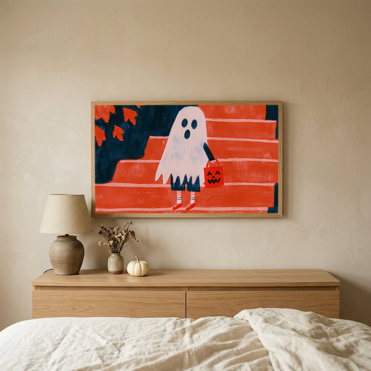 Ghost with a jack-o'-lantern bag Halloween TV art above an oak dresser in a calm bedroom