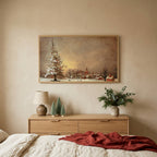Snowy tree and village Christmas TV art above an oak dresser with small bottle-brush trees in a calm bedroom