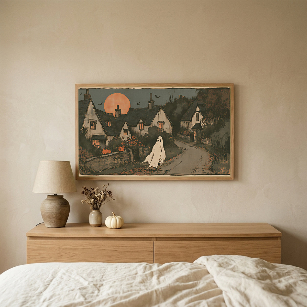Ghost village Halloween TV art above an oak dresser in a calm bedroom