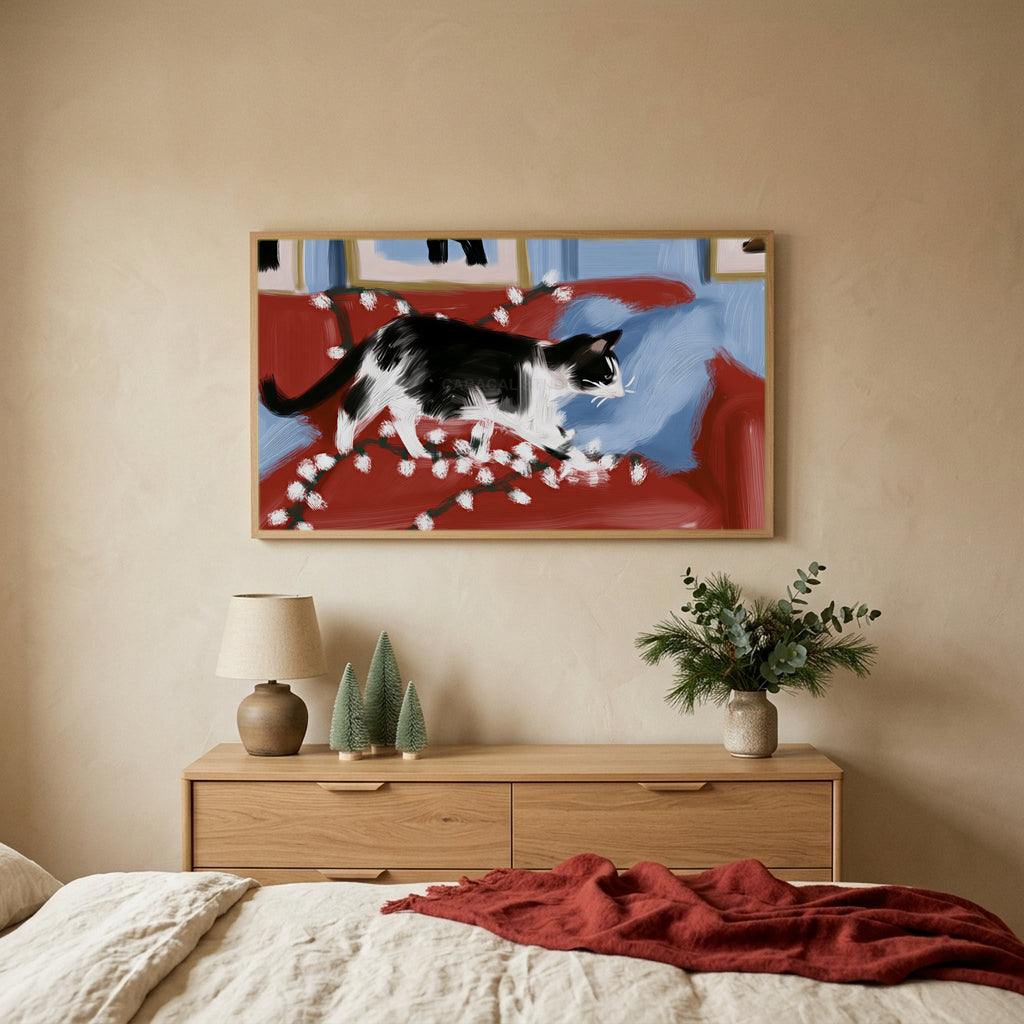 Black and white cat with Christmas lights Christmas TV art above an oak dresser with small bottle-brush trees in a calm bedroom