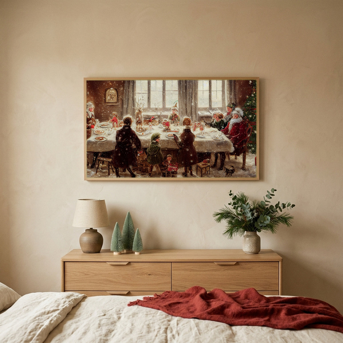 Santa at the dinner table Christmas TV art above an oak dresser with small bottle-brush trees in a calm bedroom