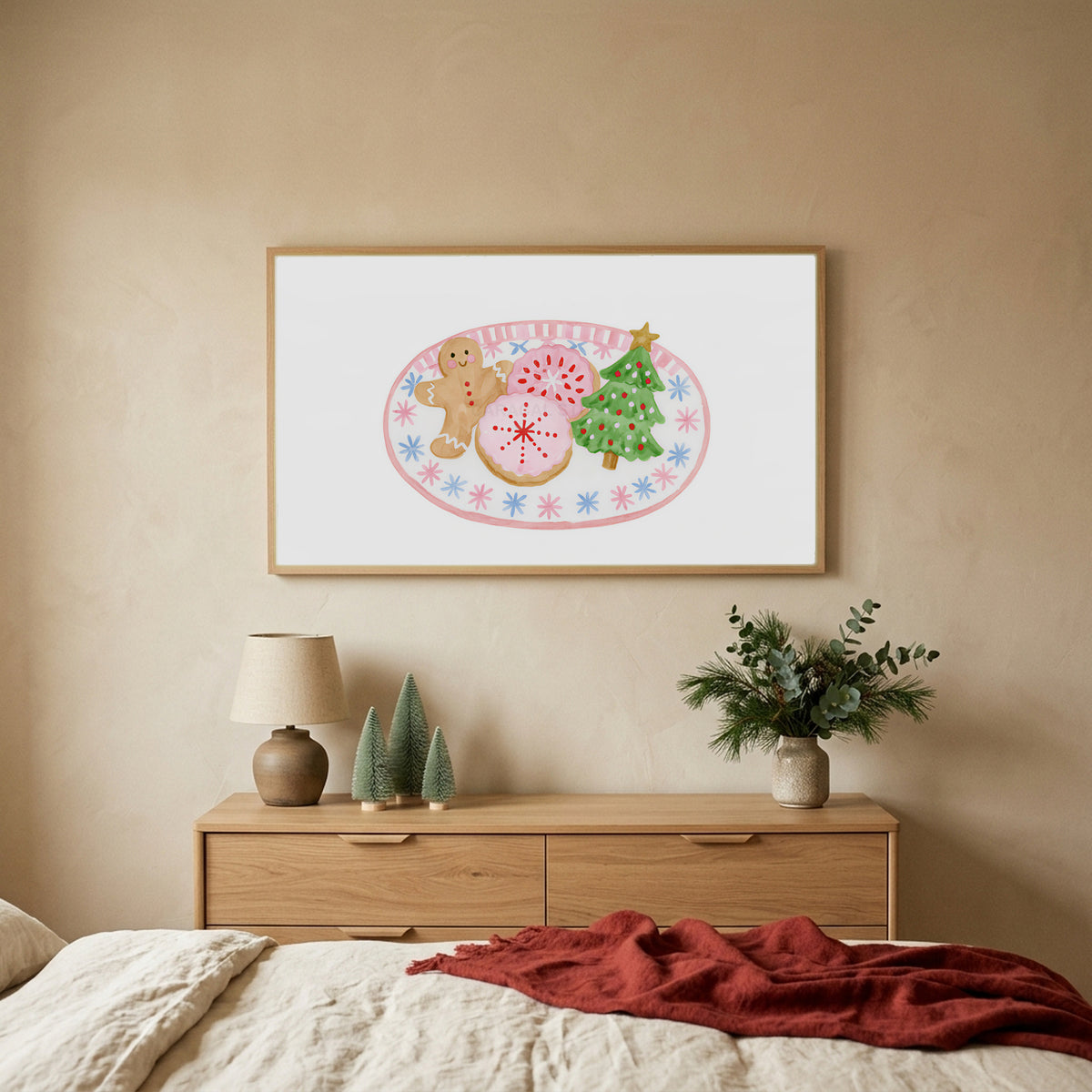 Christmas cookies TV art above an oak dresser with small bottle-brush trees in a calm bedroom