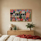 Folk art Christmas village TV art above an oak dresser with small bottle-brush trees in a calm bedroom