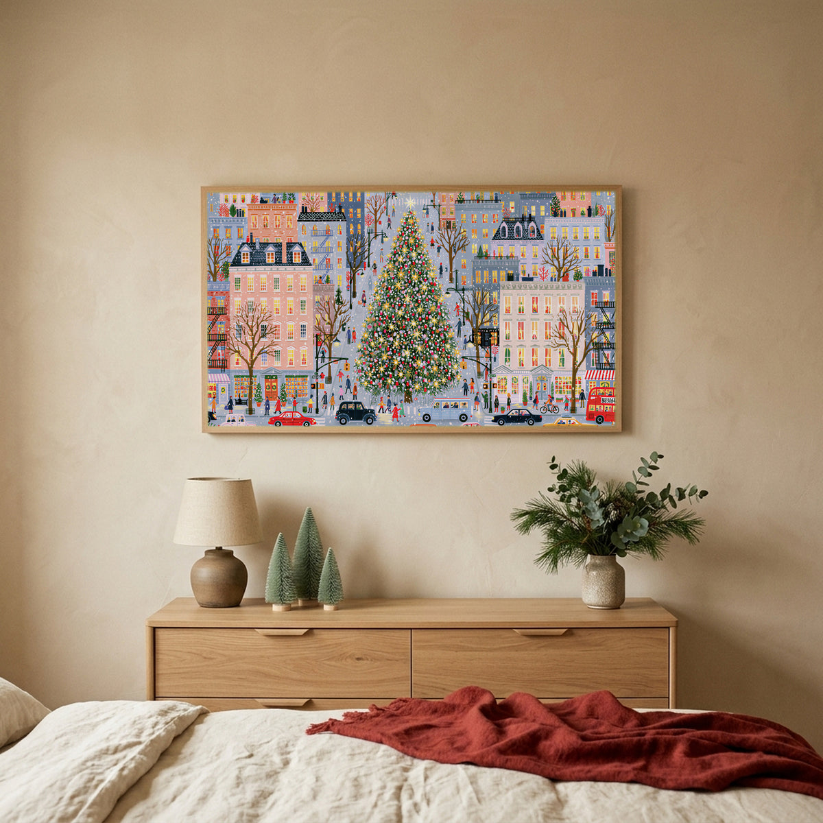 Snowy city street with a big tree TV art above an oak dresser with small bottle-brush trees in a calm bedroom