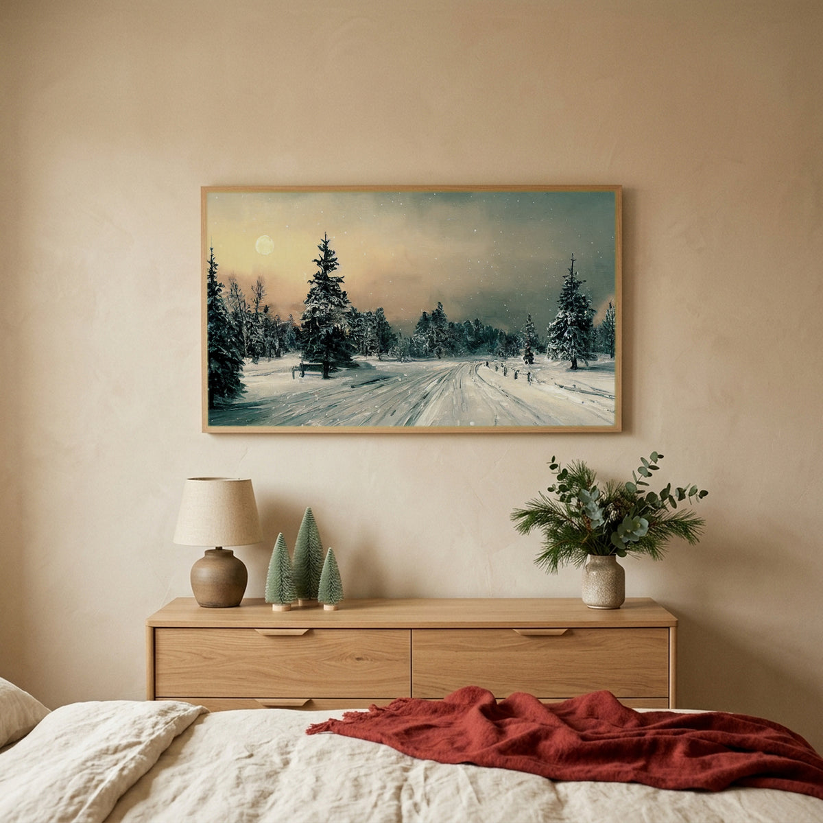 Snowy forest TV art above an oak dresser with small bottle-brush trees in a calm bedroom