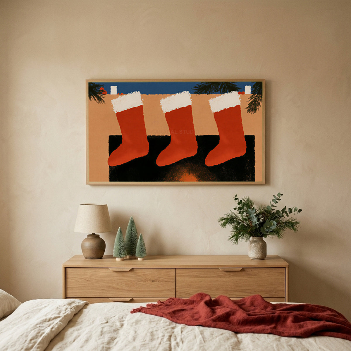 Stockings on the mantel TV art above an oak dresser with small bottle-brush trees in a calm bedroom