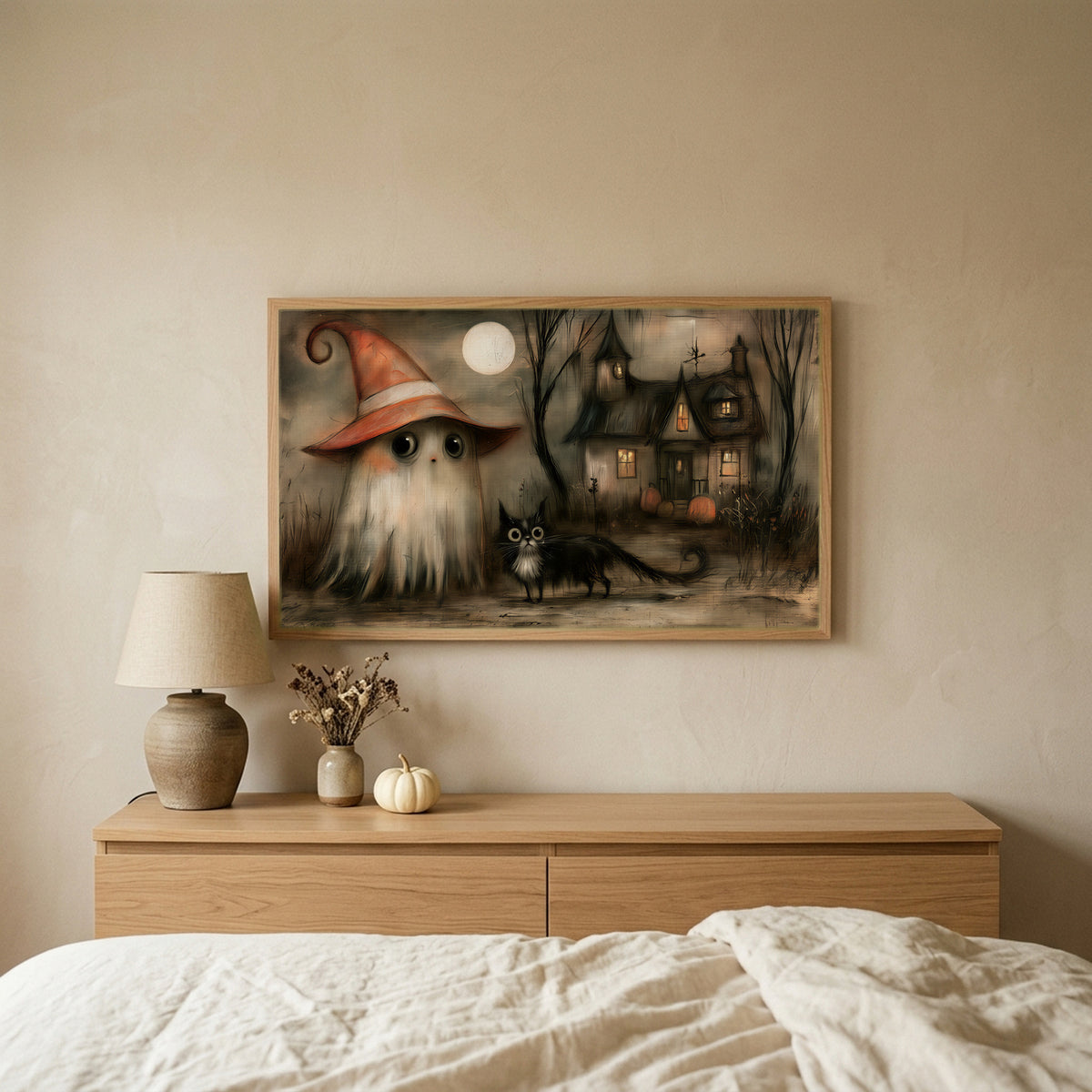 Ghost witch and black cat Halloween TV art above an oak dresser in a calm bedroom