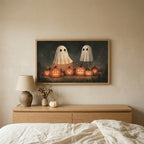 Two ghosts and jack-o'-lanterns Halloween TV art above an oak dresser in a calm bedroom