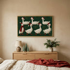 Geese in Santa hats TV art above an oak dresser with small bottle-brush trees in a calm bedroom