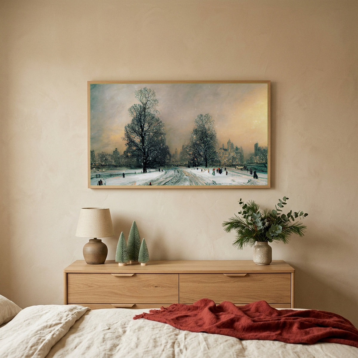 Snowy New York park TV art above an oak dresser with small bottle-brush trees in a calm bedroom