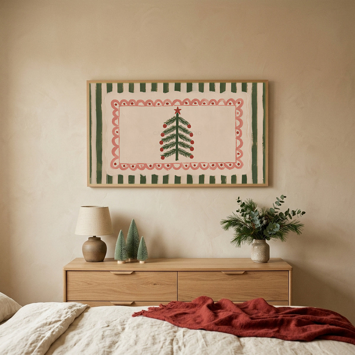 Folk Christmas tree TV art above an oak dresser with small bottle-brush trees in a calm bedroom