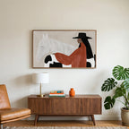 Cowgirl and her horse art on a TV above a walnut credenza with a brass lamp and a monstera plant