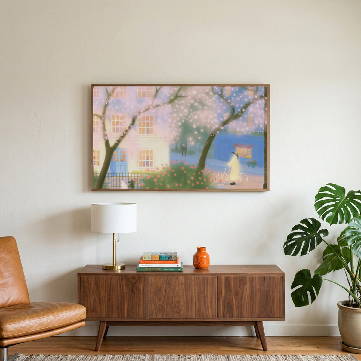 Cherry blossom street art on a TV above a walnut credenza with a brass lamp and a monstera plant