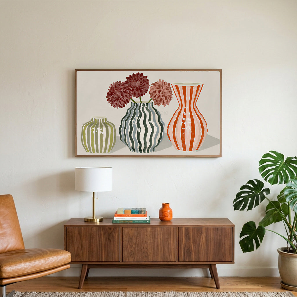 Striped vases art on a TV above a walnut credenza with a brass lamp and a monstera plant