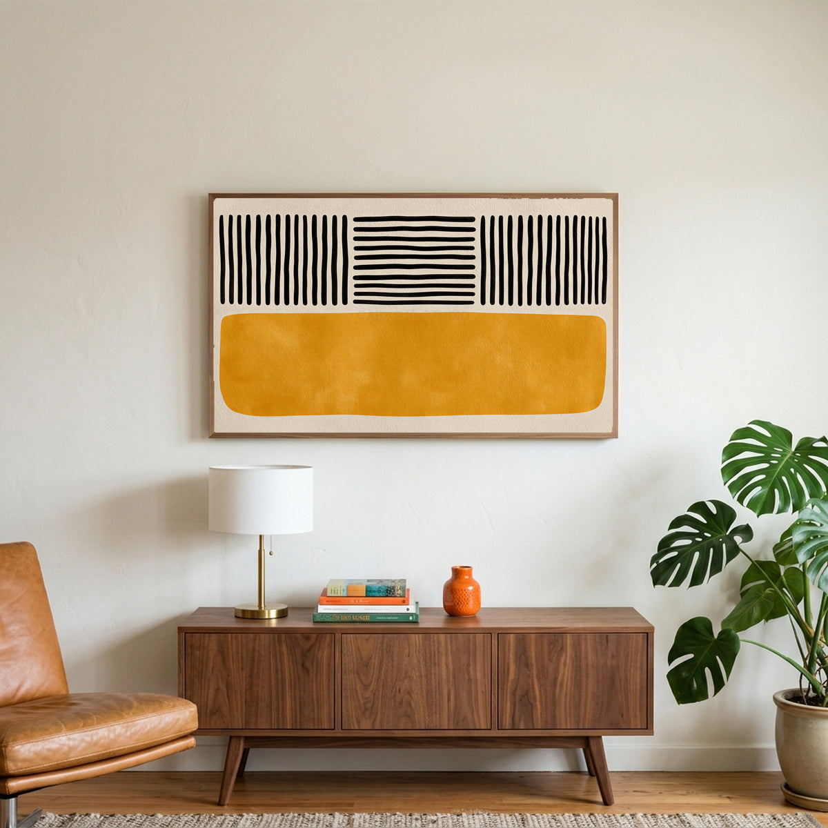 Abstract lines and color block art on a TV above a walnut credenza with a brass lamp and a monstera plant