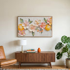 Blossom and orange art on a TV above a walnut credenza with a brass lamp and a monstera plant