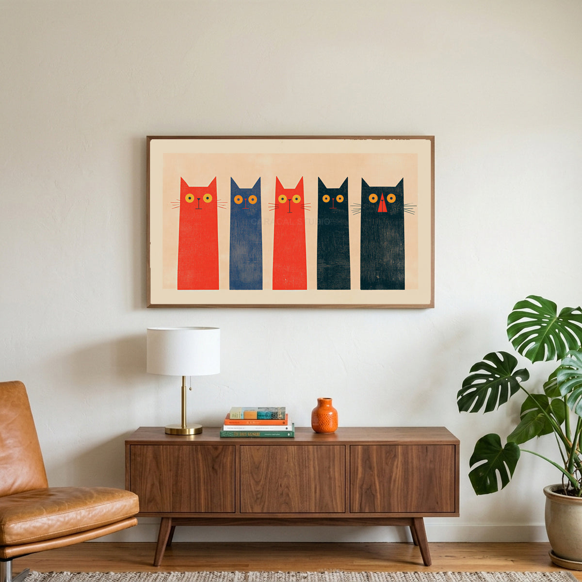 Five tall cats art on a TV above a walnut credenza with a brass lamp and a monstera plant