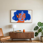 Blue hair portrait art on a TV above a walnut credenza with a brass lamp and a monstera plant