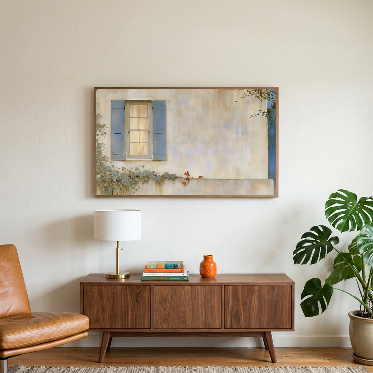Blue shutter cottage window art on a TV above a walnut credenza with a brass lamp and a monstera plant