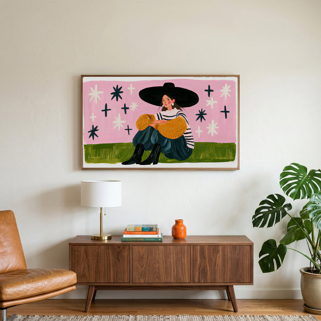 Woman in a big hat art on a TV above a walnut credenza with a brass lamp and a monstera plant