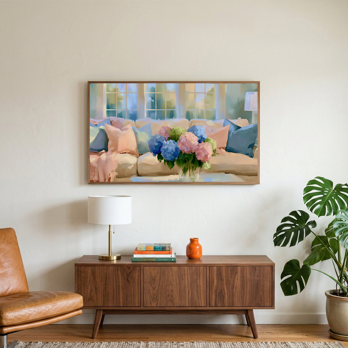 Pastel hydrangea bouquet art on a TV above a walnut credenza with a brass lamp and a monstera plant