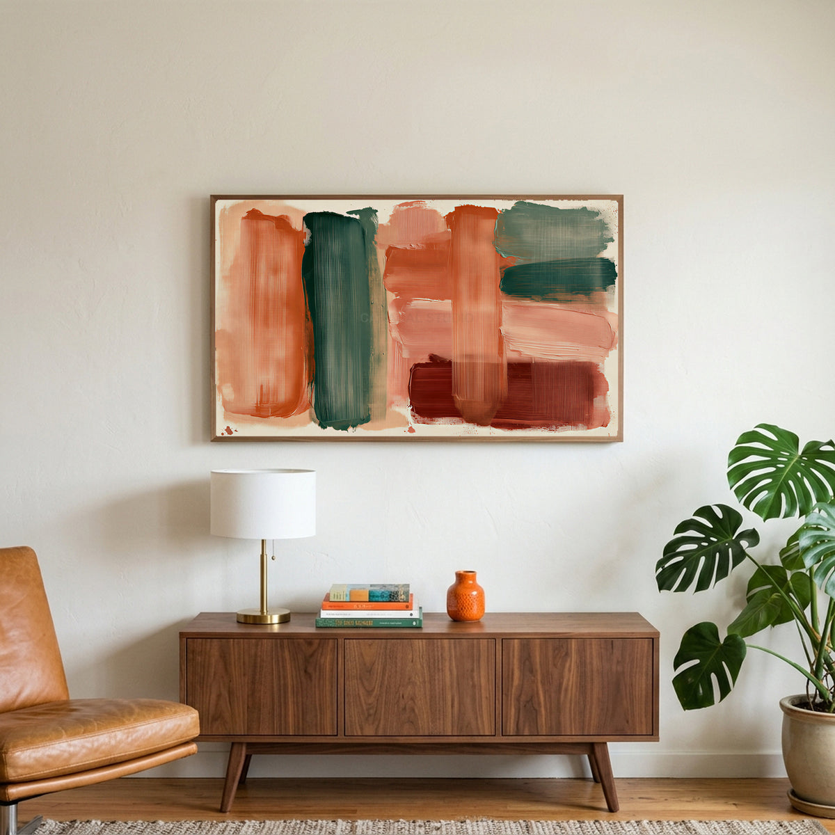 Boho brushstroke art on a TV above a walnut credenza with a brass lamp and a monstera plant