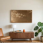 Japanese blossom art on a TV above a walnut credenza with a brass lamp and a monstera plant