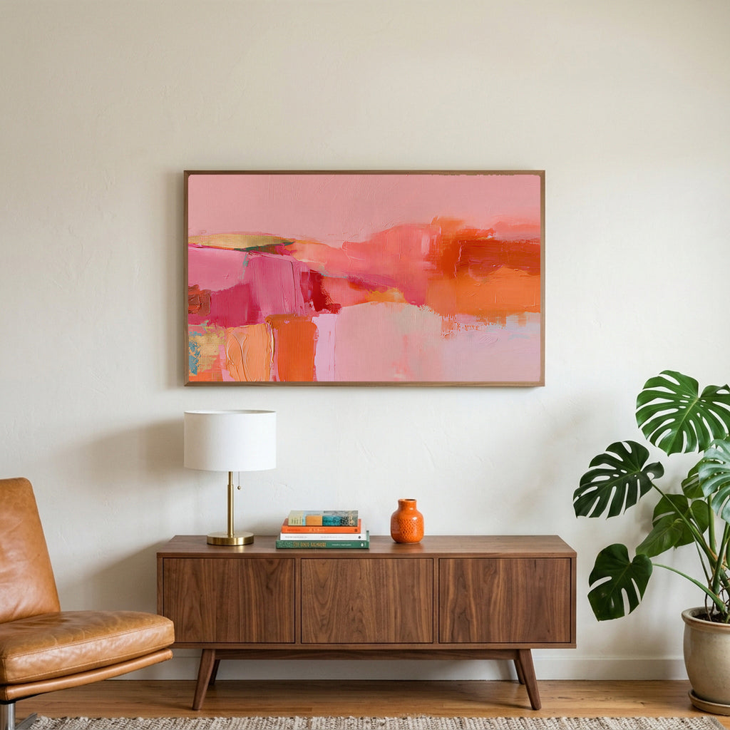 Pink abstract color blocks art on a TV above a walnut credenza with a brass lamp and a monstera plant