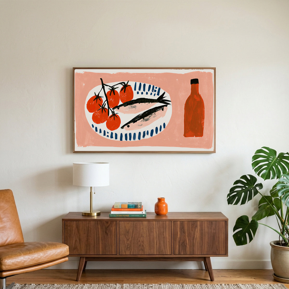 Sardines and tomatoes art on a TV above a walnut credenza with a brass lamp and a monstera plant