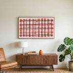 Gingham plaid with stars art on a TV above a walnut credenza with a brass lamp and a monstera plant