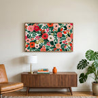 Painted roses and berries art on a TV above a walnut credenza with a brass lamp and a monstera plant