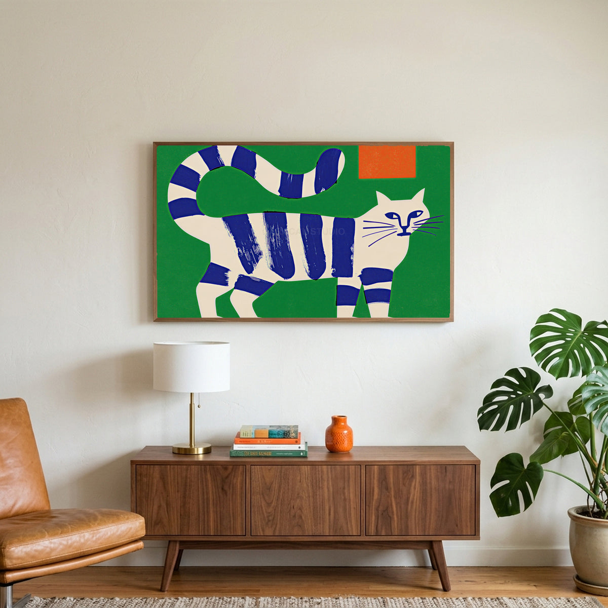 Blue striped cat art on a TV above a walnut credenza with a brass lamp and a monstera plant