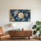 Blue and cream peonies art on a TV above a walnut credenza with a brass lamp and a monstera plant