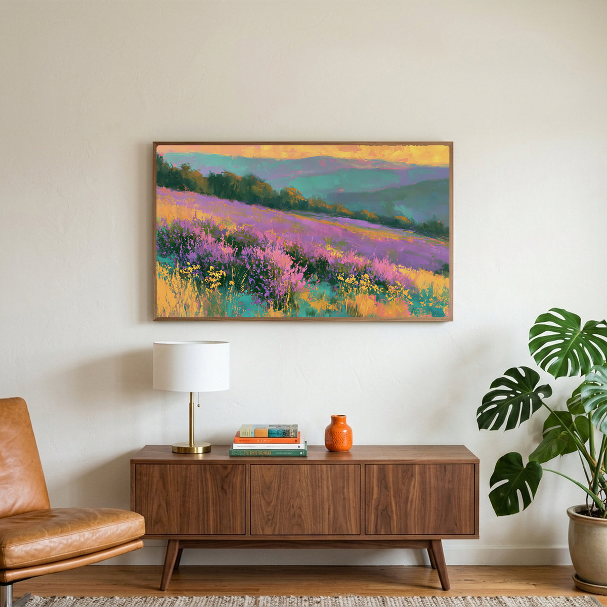 Heather hills art on a TV above a walnut credenza with a brass lamp and a monstera plant