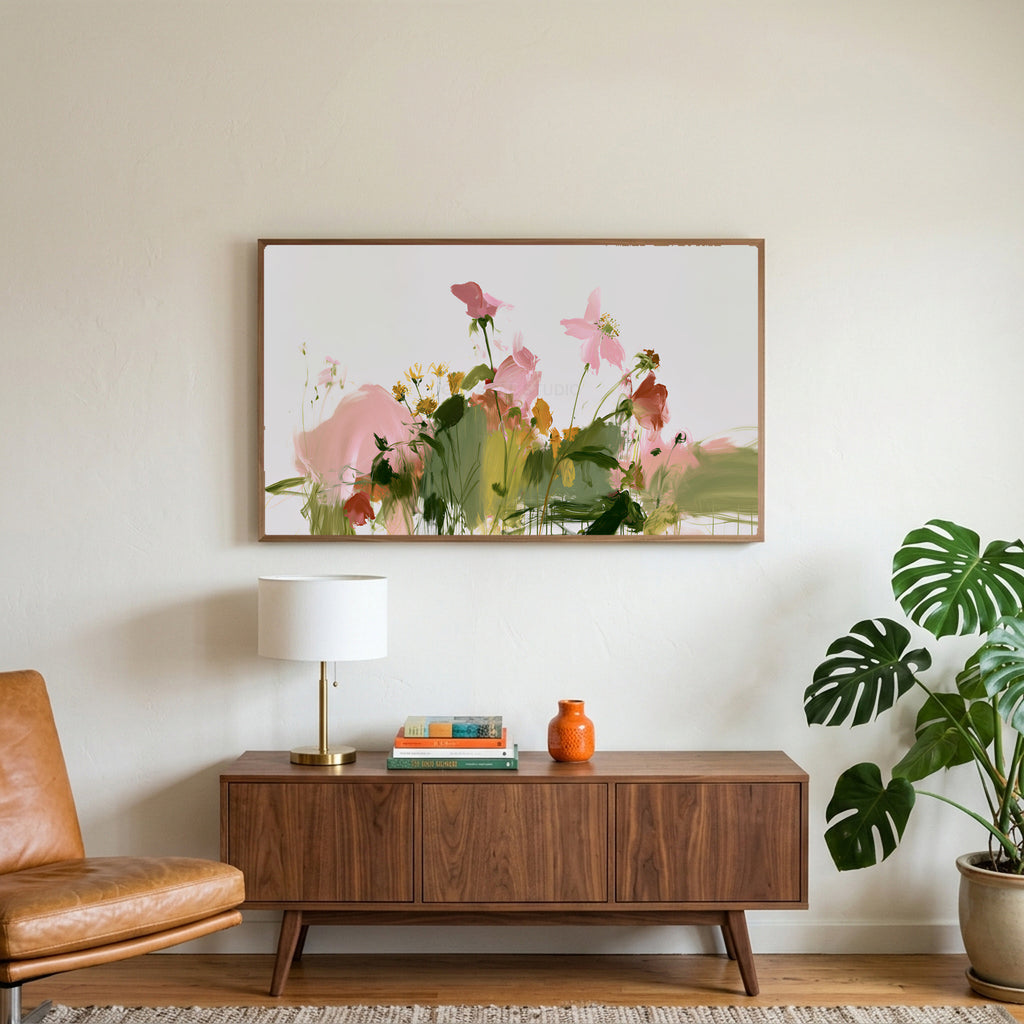 Abstract wildflowers art on a TV above a walnut credenza with a brass lamp and a monstera plant