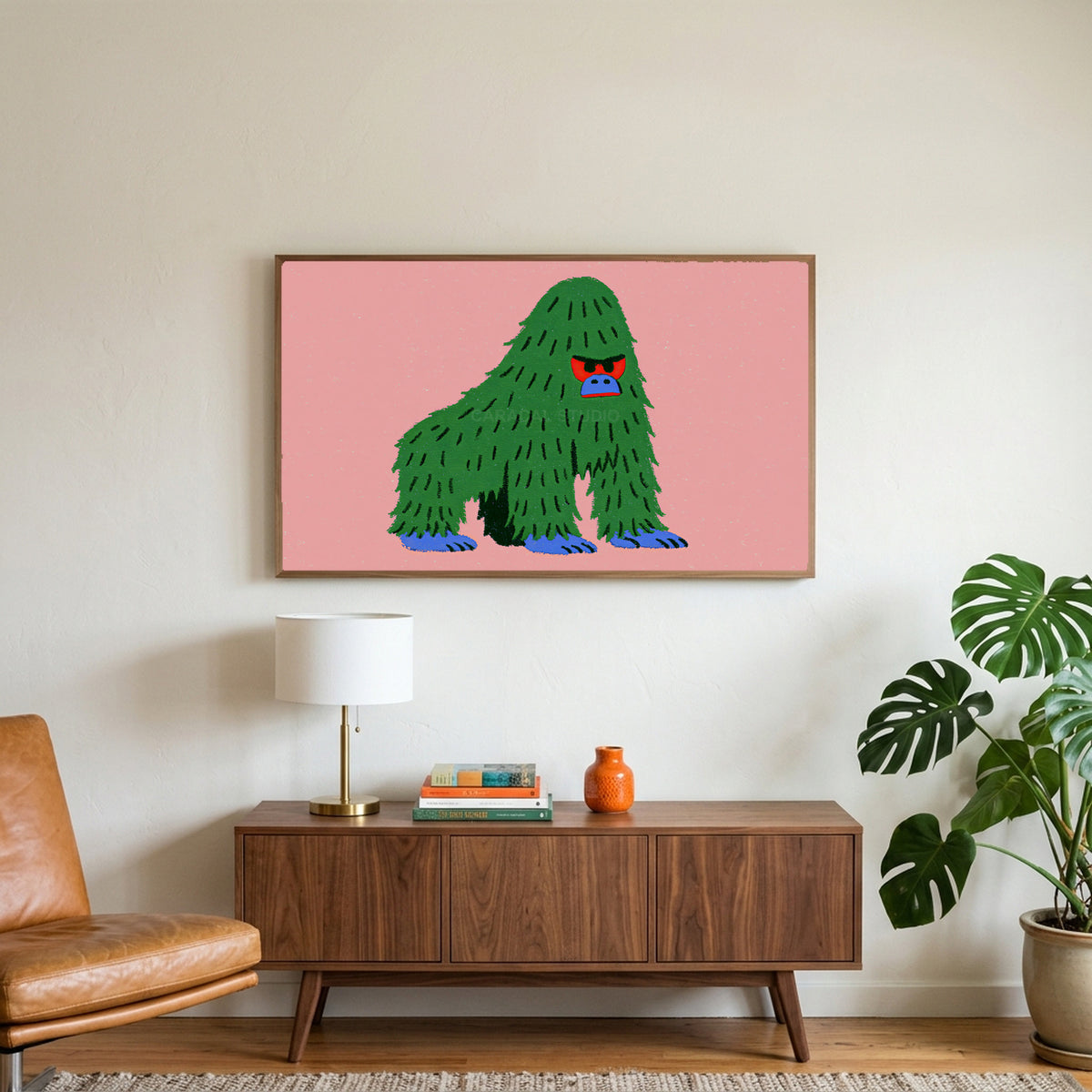 Grumpy gorilla art on a TV above a walnut credenza with a brass lamp and a monstera plant