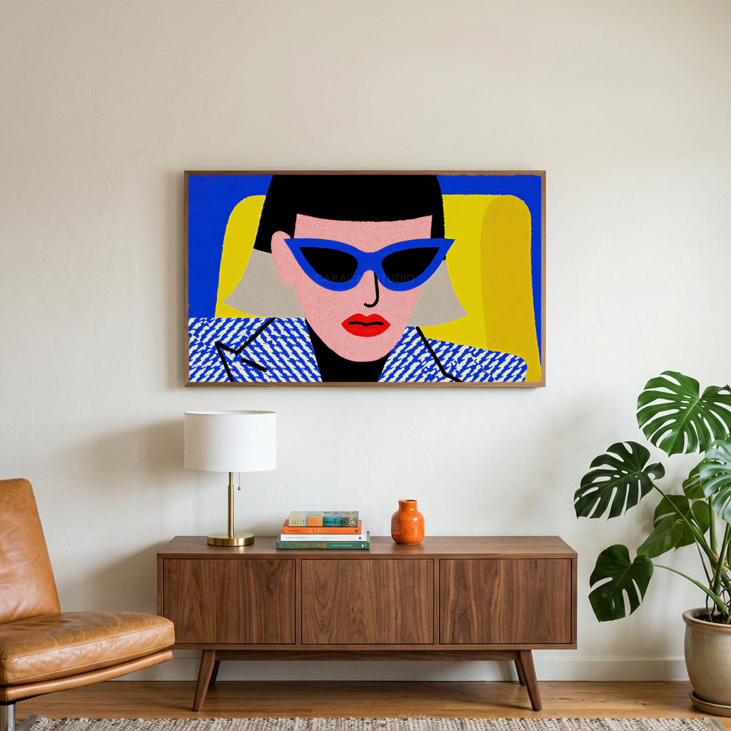 Pop art woman in sunglasses art on a TV above a walnut credenza with a brass lamp and a monstera plant