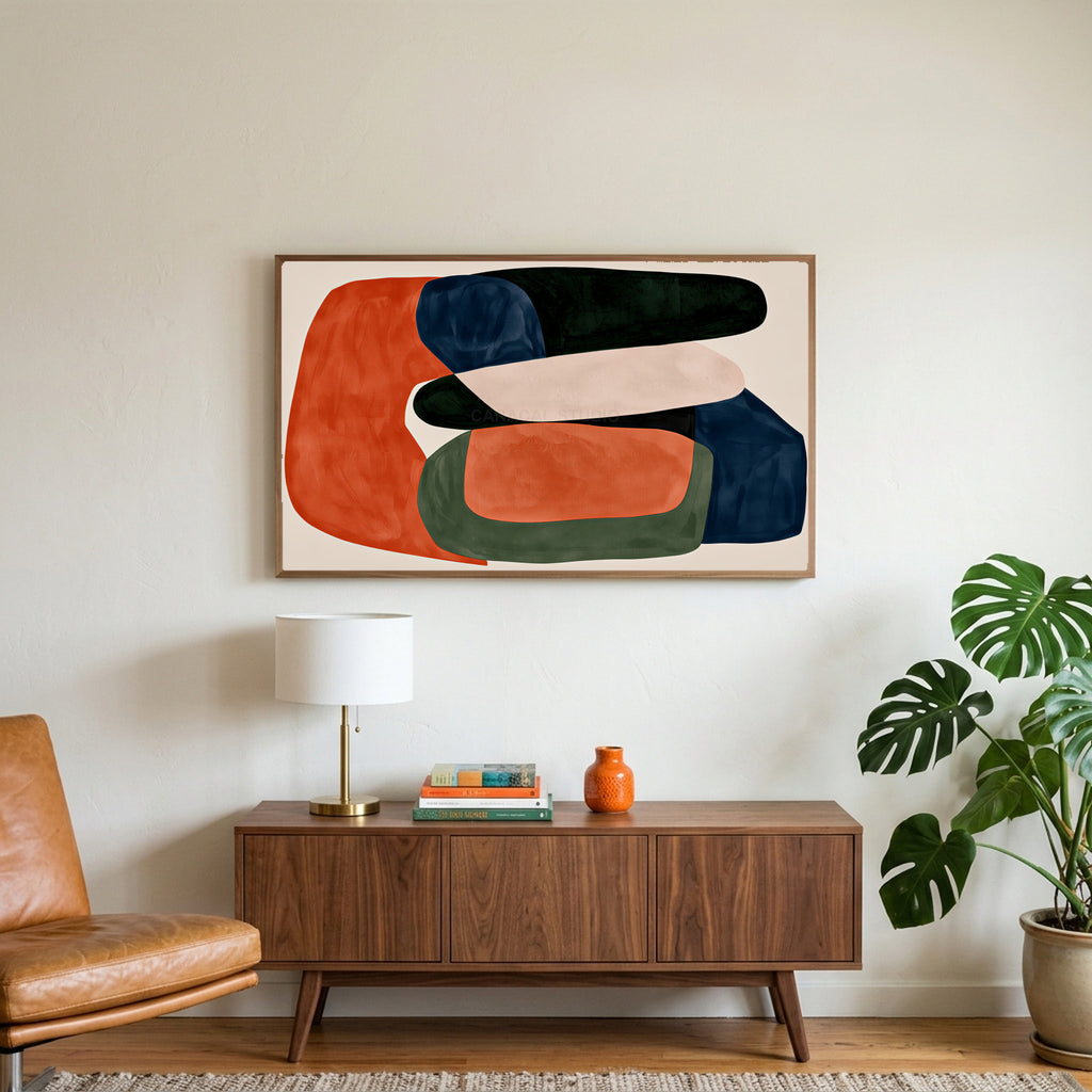 Abstract organic shapes art on a TV above a walnut credenza with a brass lamp and a monstera plant