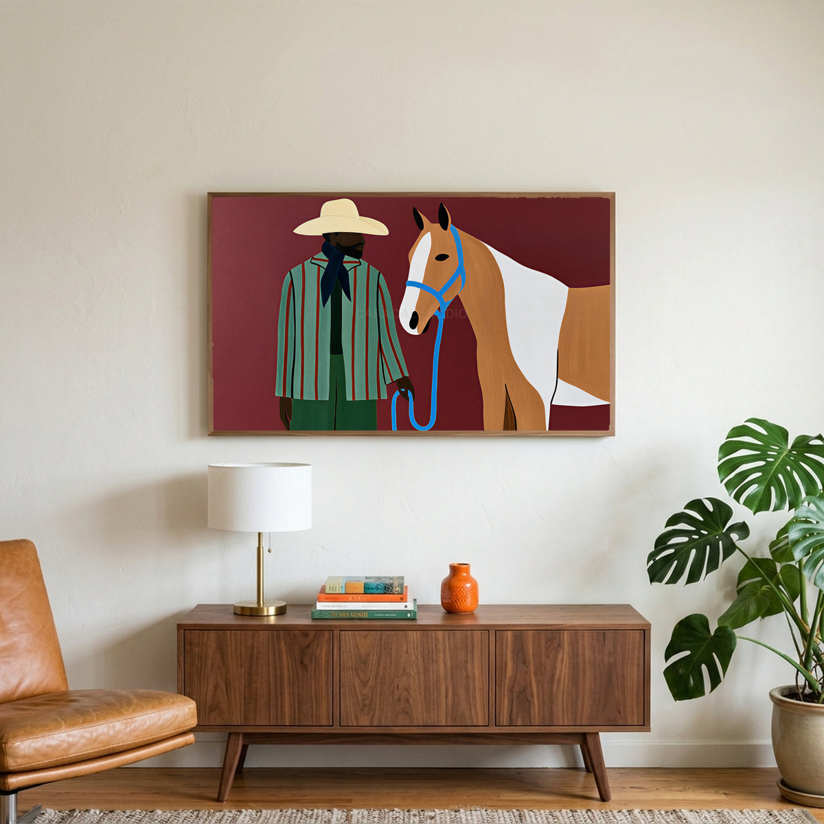 Cowboy with a horse art on a TV above a walnut credenza with a brass lamp and a monstera plant