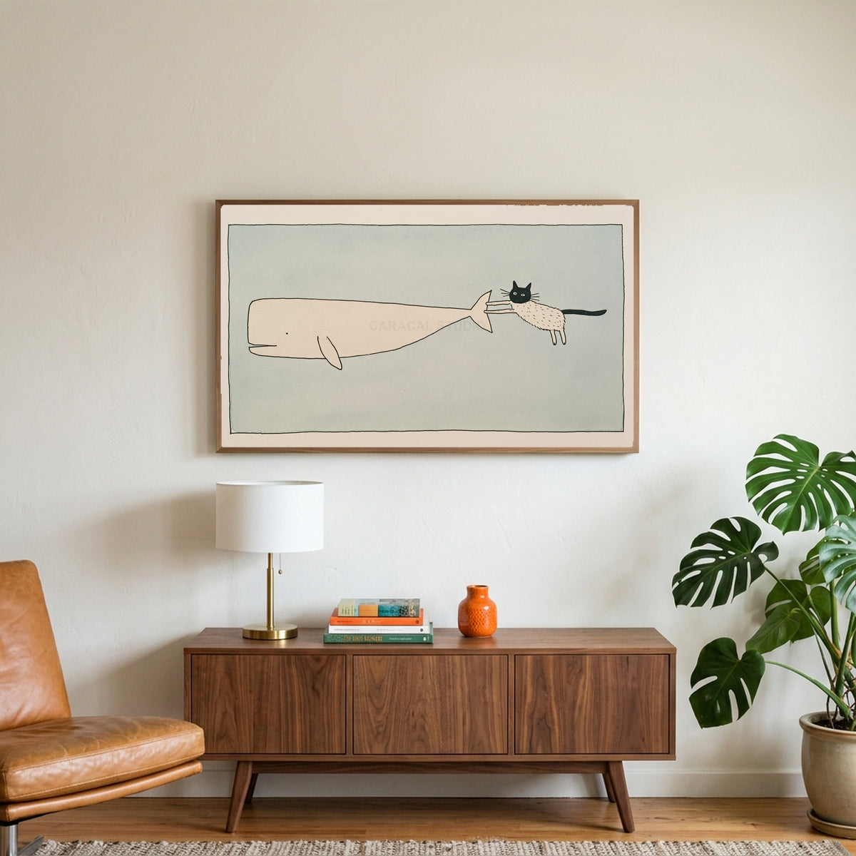Cat and whale art on a TV above a walnut credenza with a brass lamp and a monstera plant