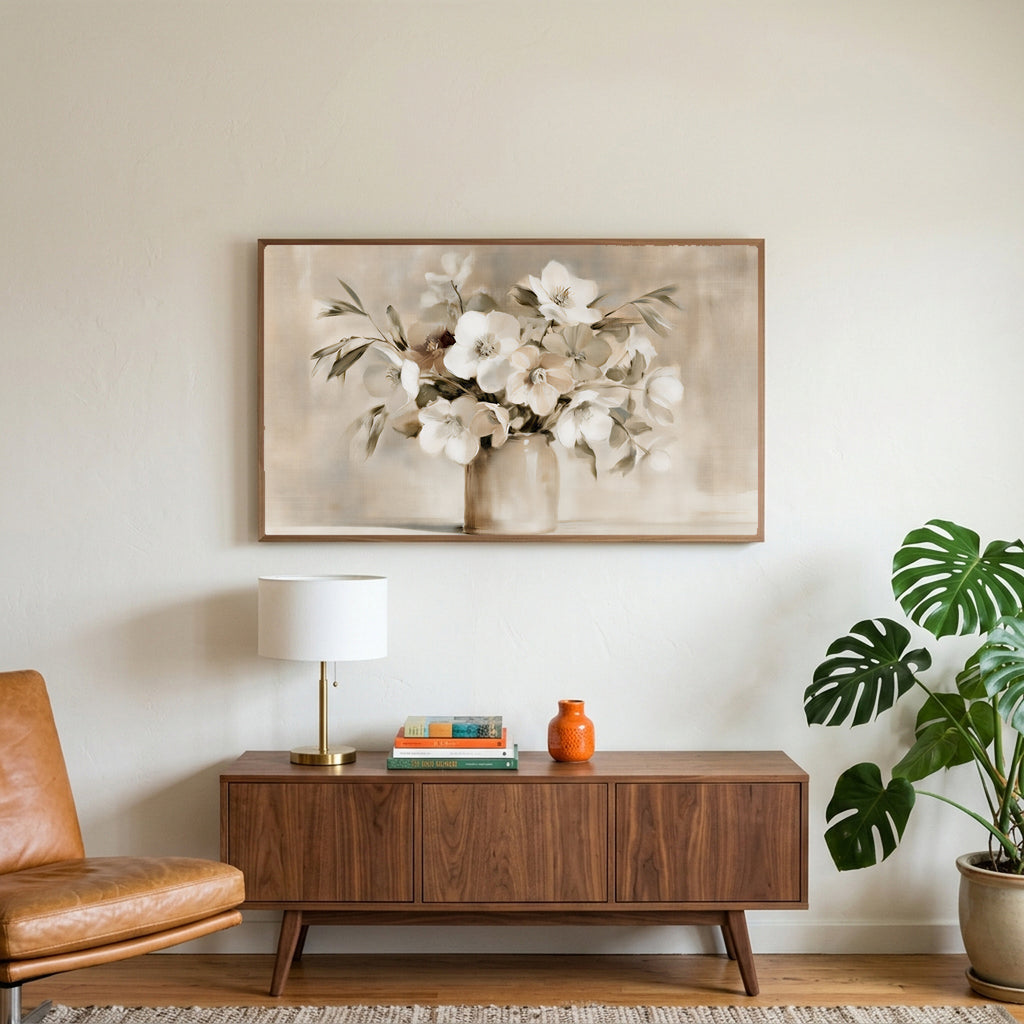 White hellebores art on a TV above a walnut credenza with a brass lamp and a monstera plant